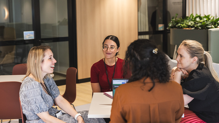 Employees sitting around a table smiling