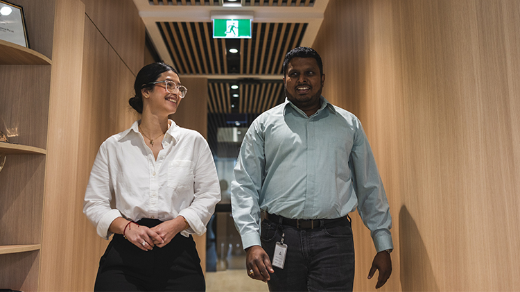 Two employees walking down a hallway